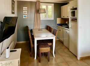 una pequeña cocina con mesa blanca y sillas en Les Restanques 4027 vue mer grande terrasse en Grimaud