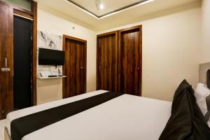 1 dormitorio con cama blanca y armarios de madera en Hotel Dream en Hisār