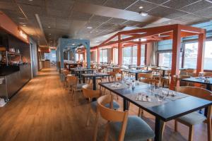 - une salle à manger avec des tables, des chaises et des fenêtres dans l'établissement Belambra Clubs Flaine Panorama, à Flaine