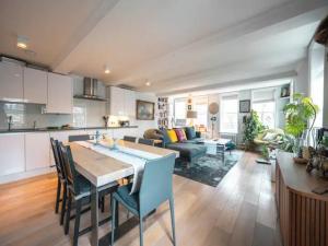 a kitchen and living room with a table and chairs at Pass the Keys Kingsway Place - Stunning 1 Bedroom Duplex in London