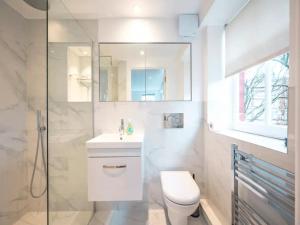 a bathroom with a toilet and a sink and a shower at Pass the Keys Kingsway Place - Stunning 1 Bedroom Duplex in London
