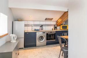 eine Küche mit einem Kühlschrank und einer Waschmaschine in der Unterkunft Les Ecuries du SEQUE in Saint-Martin-de-Seignanx