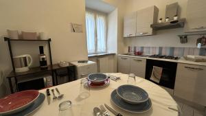 een keuken met een tafel met borden erop bij Ankon Apartment La Casa di Joye & Nemi in Ancona
