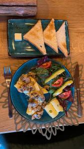 a plate of food with bread and vegetables on a table at BerBen House in Vorokhta