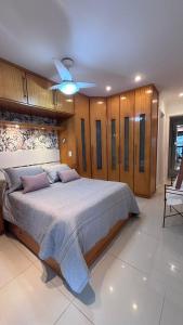 a bedroom with a large bed and a ceiling fan at Apartamento Praia Barra da Tijuca -Acolhedor e Confortável in Rio de Janeiro