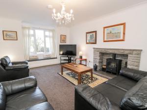 a living room with a couch and a fireplace at Halcyon in Moelfre