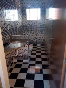 a bathroom with a black and white checkered floor at Recanto Beija-Flor in Ribeirão Preto