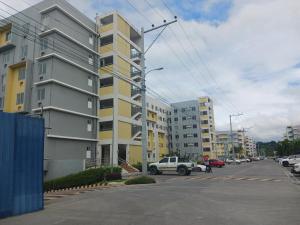 een gebouw op een straat met auto's geparkeerd op een parkeerplaats bij Entire 2BR condo 8 Spatial Maa Davao in Davao City