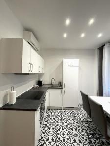 a kitchen with white cabinets and a black and white floor at Home Sweet Home - Stephansdom in Vienna