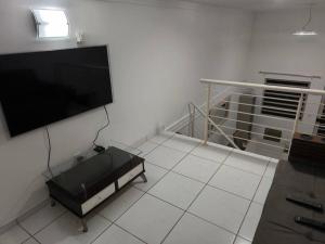 sala de estar con TV de pantalla plana en la pared en Seu cantinho em Águas en Águas de Lindóia