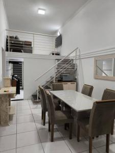 阿瓜斯迪林多亞的住宿－Seu cantinho em Águas，一间带桌椅和楼梯的用餐室