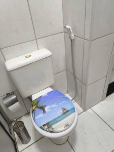 uma casa de banho com um WC com uma fotografia de uma praia em Seu cantinho em Águas em Águas de Lindoia