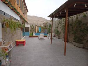 um pátio exterior com uma piscina, mesas e cadeiras em Villa Alfonso - Casa playa con piscina temperada em Lima