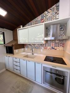 a kitchen with a sink and a counter top at Casa pé na areia em praia paradisíaca com piscina frente mar in Balneário Camboriú