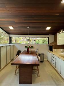 cocina con mesa de madera en una habitación en Casa pé na areia em praia paradisíaca com piscina frente mar, en Balneário Camboriú