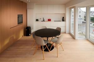 une salle à manger avec une table et des chaises noires dans l'établissement Saint Tropez 0202, à La Panne