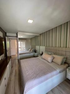 1 dormitorio grande con 1 cama grande y TV en Casa pé na areia em praia paradisíaca com piscina frente mar, en Balneário Camboriú