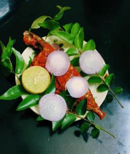 a plate of food with vegetables on top at Suryas Home Stay in Devikolam