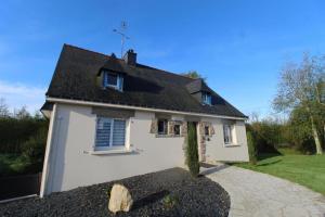 a white house with a black roof and a driveway at Studio Est proche centre ville in Loudéac