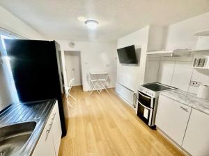 Cosy two bedroom apartment,SE13 في لندن: مطبخ مع مغسلة وموقد فرن علوي