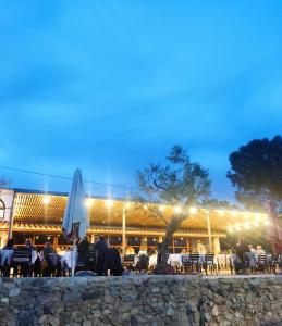 un gruppo di persone sedute al ristorante di notte di Camping El Pasqualet a Caldes de Montbui
