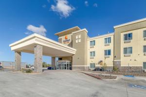 a front view of a hotel with a parking lot at Comfort Suites in Pecos