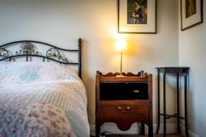 a bedroom with a bed and a nightstand with a lamp at The Victorian House in York