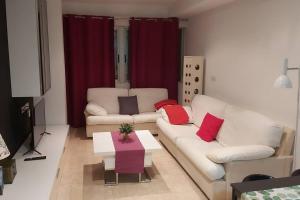 uma sala de estar com dois sofás brancos e uma mesa em El estudio de Inma em Burriana
