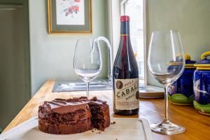 ein Stück Kuchen und zwei Weingläser auf einem Tisch in der Unterkunft The Victorian House in York + 9 Fotos