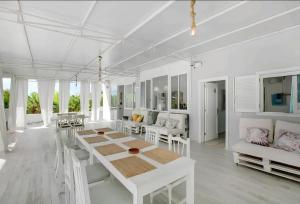 a white dining room with a table and chairs at Tropical Oasis Villa Playa Paraiso in Playa Paraiso