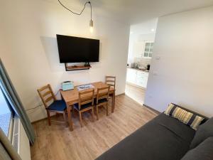 a living room with a table and a tv at Apartment House Prezlc in Kranjska Gora