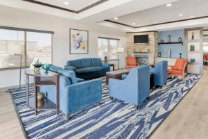 a living room with blue furniture and a fireplace at Comfort Suites in Pecos
