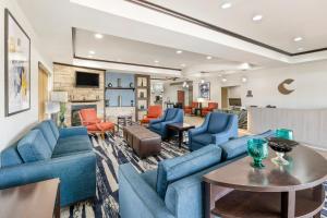 a living room with blue couches and a table at Comfort Suites in Pecos
