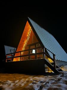 a building with a solar roof in the snow at Rock Valley Cabins in Ibăneşti