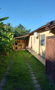 uma casa com um jardim de relva ao lado de um edifício em Cantinho Caiçara em Ilhabela