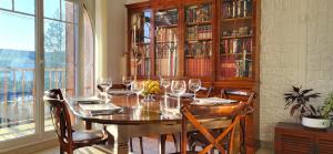 une salle à manger avec une table et des verres à vin dans l'établissement Konforta : Paisible maison d'été avec grand jardin, à Sainte-Geneviève-des-Bois