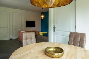 a dining room with a wooden table and chairs at Luxe vakantiebungalow casa Cranenweyer in Kerkrade