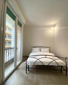 a bed in a room with a large window at Farolfi Apartments Galliera Rooms & Apartments in Bologna