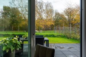 a sliding glass door leading to a patio with a table at Luxe vakantiebungalow casa Cranenweyer in Kerkrade