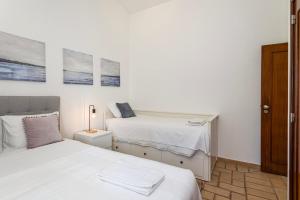 The Albufeira Concierge - Villa Pool & Tennis في Galé: غرفة نوم بيضاء بسريرين ومصباح
