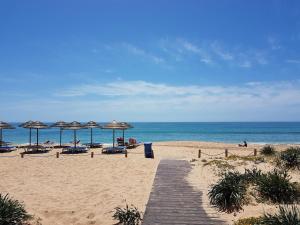 The Albufeira Concierge - Villa Pool & Tennis في Galé: شاطئ مع المظلات والكراسي والمحيط +19 صورة
