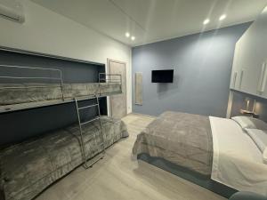 a bedroom with two bunk beds and a flat screen tv at Cliò guest house in Ercolano