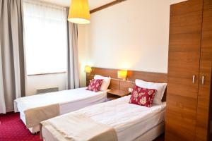 ein Hotelzimmer mit 2 Betten und einem Fenster in der Unterkunft Vihren Royal Palace in Bansko