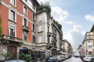 eine Stadtstraße mit Autos, die vor den Gebäuden geparkt sind in der Unterkunft St James Suite in Mailand