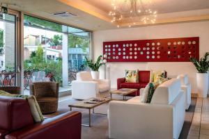 eine Lobby mit Sofas, Stühlen und Fenstern in der Unterkunft Domino Suite Hotel & Residence in Lido di Jesolo