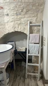 a bathroom with a ladder next to a sink and a shelf at La dimora di zio Nino in Martina Franca
