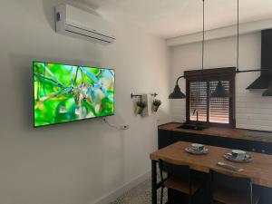 a living room with a television hanging on a wall at Río Genil in Pinos Genil