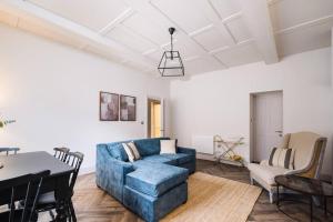 a living room with a blue couch and a table at Great Escapes Oundle Flat 3 in Oundle