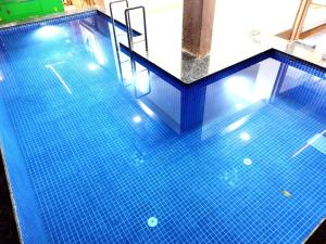 una piscina con suelo de baldosa azul y escaleras en Hotel comfort inn en Calangute