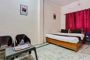 a hotel room with a bed and a table and a table sidx sidx at OYO Hotel Trishakti Homestay in Lucknow